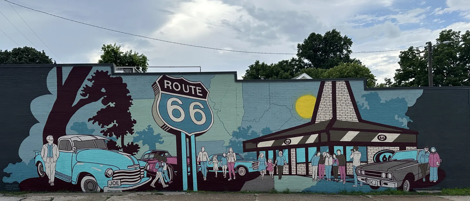 The Route 66 mural on the east wall of the future Plaid Coffee Roasters at 463 E. Vandalia Street in Edwardsville: a Route 66 shield, an Illinois map, classic cars, and a mid-century diner under a painted sun